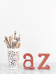 Image showing Paintbrushes with metal A and Z letters on marble surface