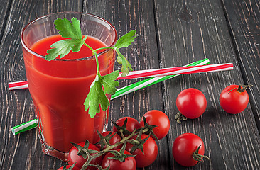 Image showing Glass of tomato juice on wooden table