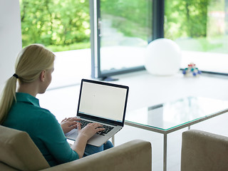 Image showing Young woman using laptop at home