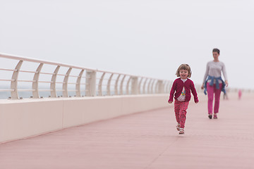 Image showing mother and cute little girl on the promenade by the sea