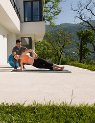 Image showing woman with personal trainer doing morning yoga exercises