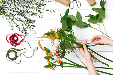 Image showing Female florist making beautiful bouquet at flower shop