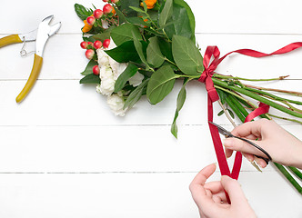 Image showing Female florist making beautiful bouquet at flower shop