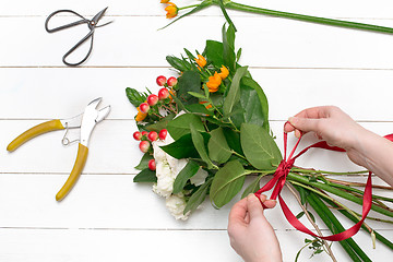 Image showing Female florist making beautiful bouquet at flower shop