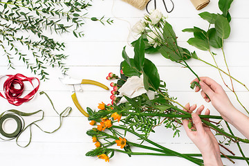 Image showing Female florist making beautiful bouquet at flower shop