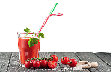Image showing Glass of tomato juice on a wooden table