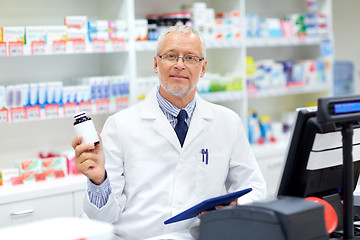 Image showing senior apothecary with drug at pharmacy