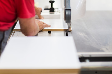 Image showing carpenter with panel saw and fibreboard at factory