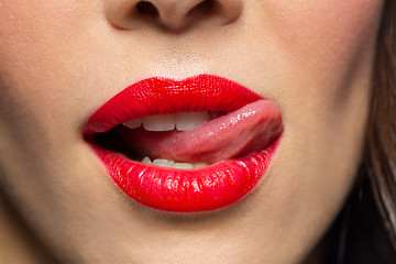 Image showing close up of woman with red lipstick licking lips