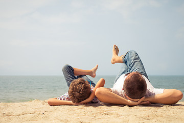 Image showing Father and son playing on the beach at the day time.