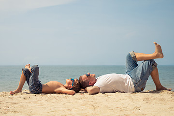 Image showing Father and son playing on the beach at the day time.