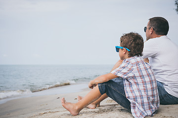 Image showing Portrait of young sad little boy and father sitting outdoors at 