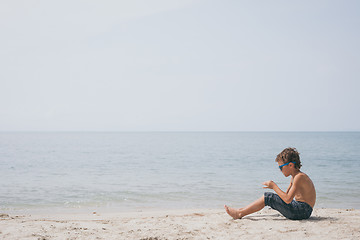 Image showing One happy little boy playing on the beach at the day time.