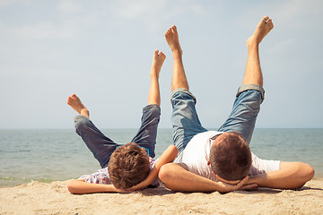 Image showing Father and son playing on the beach at the day time.