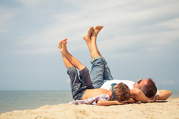 Image showing Father and son playing on the beach at the day time.