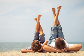 Image showing Father and son playing on the beach at the day time.