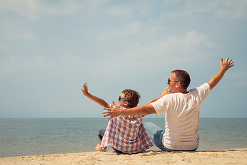 Image showing Father and son playing on the beach at the day time.