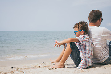 Image showing Portrait of young sad little boy and father sitting outdoors at 