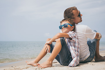 Image showing Father and son playing on the beach at the day time.