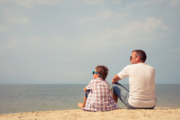 Image showing Father and son playing on the beach at the day time.