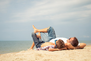 Image showing Father and son playing on the beach at the day time.