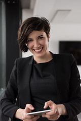 Image showing Elegant Woman Using Mobile Phone by window in office building