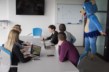 Image showing boss dresed as bear having fun with business people in trendy of