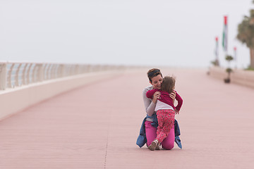 Image showing mother and cute little girl on the promenade by the sea