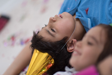 Image showing kids  blowing confetti while lying on the floor