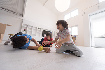 Image showing boys having fun with an apple on the floor