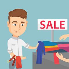 Image showing Young man choosing clothes in a shop on sale.