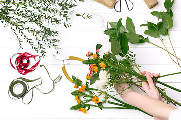 Image showing Female florist making beautiful bouquet at flower shop