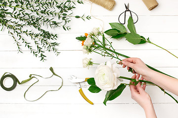 Image showing Female florist making beautiful bouquet at flower shop