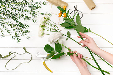 Image showing Female florist making beautiful bouquet at flower shop