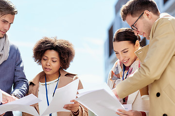 Image showing international business team with papers outdoors