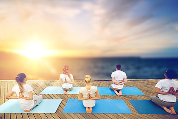 Image showing group of people doing yoga outdoors