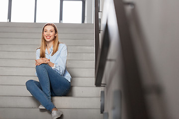 Image showing happy smiling woman or student sitting on stairs