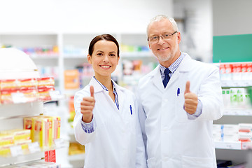 Image showing happy apothecaries showing thumbs up at pharmacy