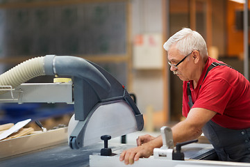 Image showing carpenter working with panel saw at factory