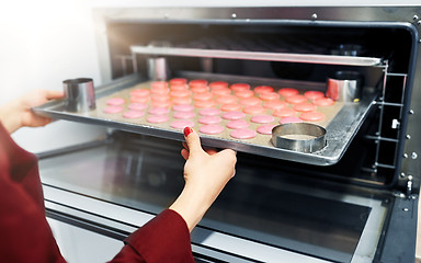 Image showing chef with macarons on oven tray at confectionery