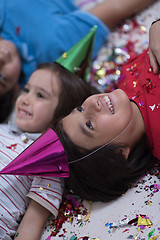 Image showing kids  blowing confetti while lying on the floor