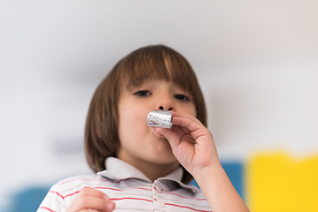 Image showing kid blowing a noisemaker