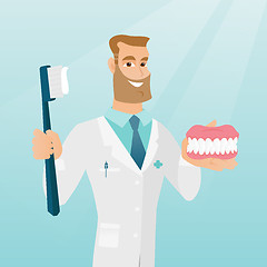 Image showing Dentist with a dental jaw model and a toothbrush.