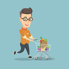 Image showing Man running with a trolley full of purchases.