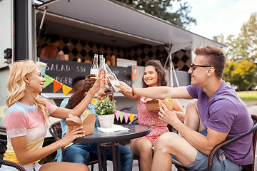 Image showing friends clinking drinks and eating at food truck