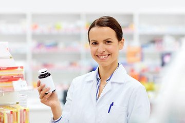 Image showing happy female apothecary with drug at pharmacy