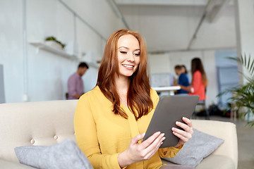 Image showing redhead woman with tablet pc working at office