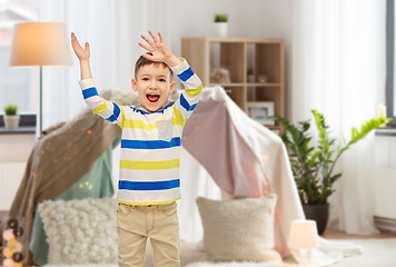 Image showing happy little boy waving hands at home