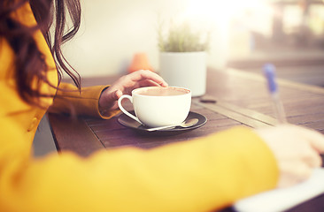 Image showing close up of woman drinking cocoa at cafe