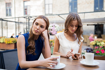 Image showing young women with smartphone and coffee at cafe